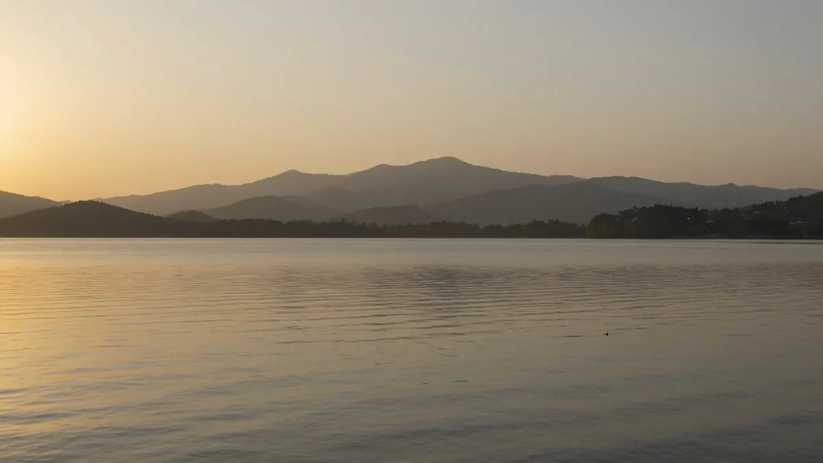 Lago refletindo a luz dourada do amanhecer